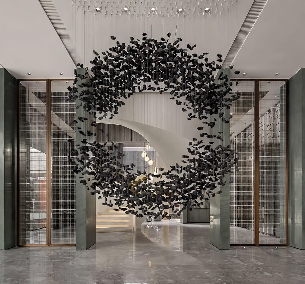 A bright lobby under a large black sculptural chandelier