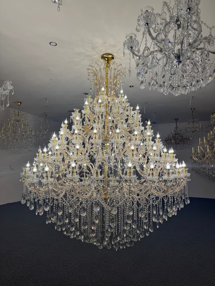 A large multi-tier crystal chandelier lit on the showroom floor