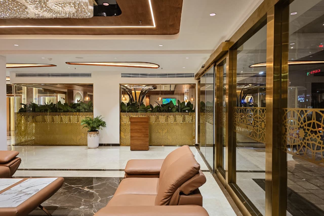 A hotel reception lounge lit by warm cove lighting and a crystal ceiling
